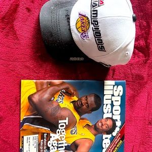Lakers hat and magazine. Hat is new in box but has smudge on lid as pictured.